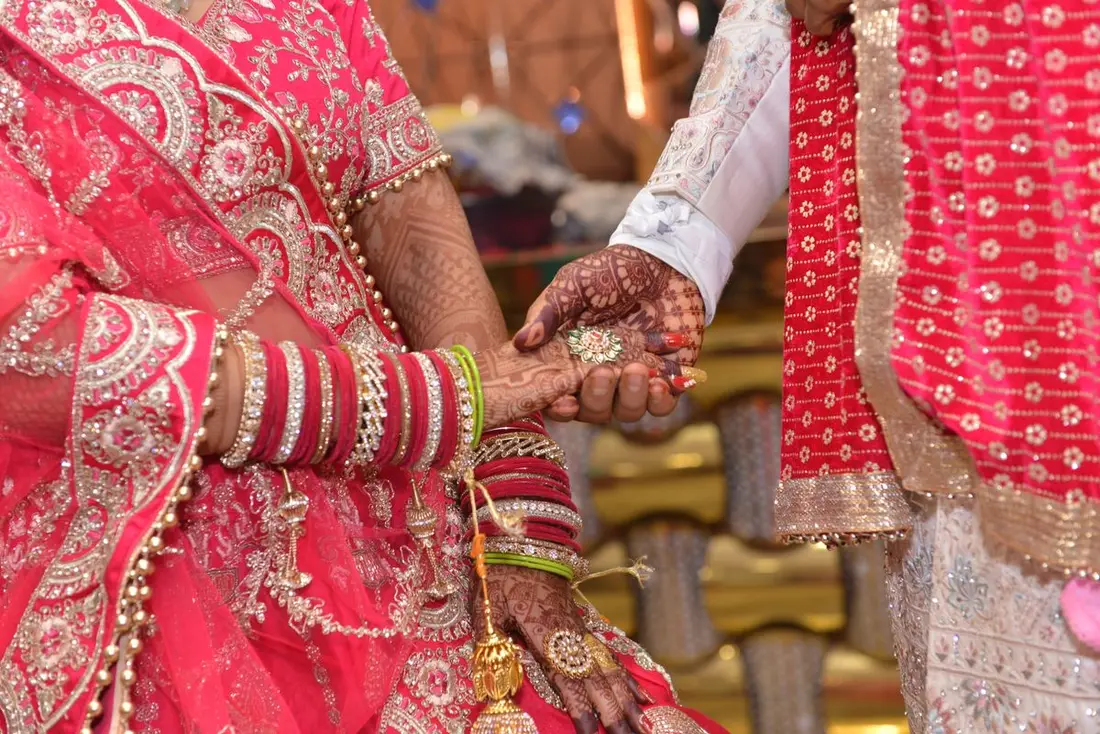 Couple in wedding finery glowing softly behind the gold card